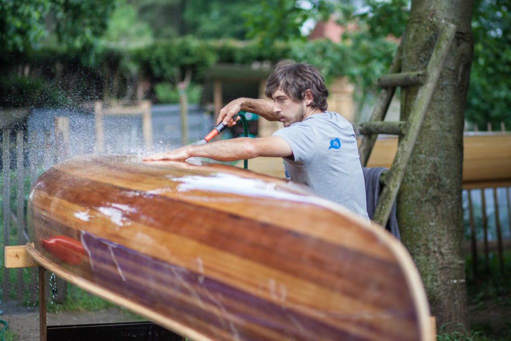 A wood strip canoe in need of revivification Johannes washing the canoe A wood strip canoe in need of revivification