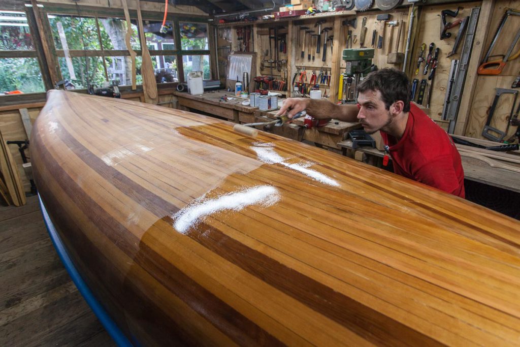 A wood strip canoe in need of revivification Johannes varnishing the canoe A wood strip canoe in need of revivification