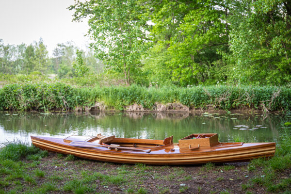 a wooden fishing canoe on the river bank
