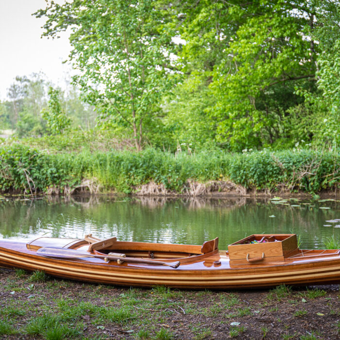 a wooden fishing canoe on the river bank