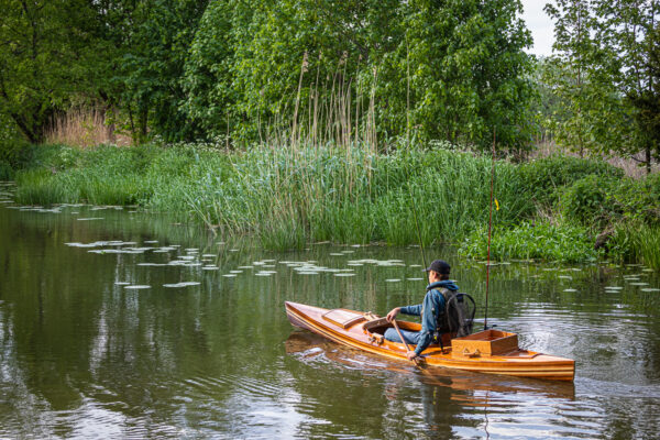 een houten viskanoop de rivier